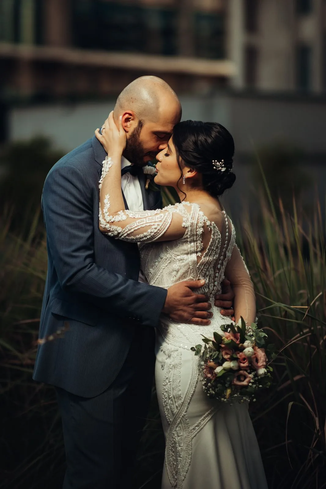 Retrato de los novios con el ramo de novia en tonos blush